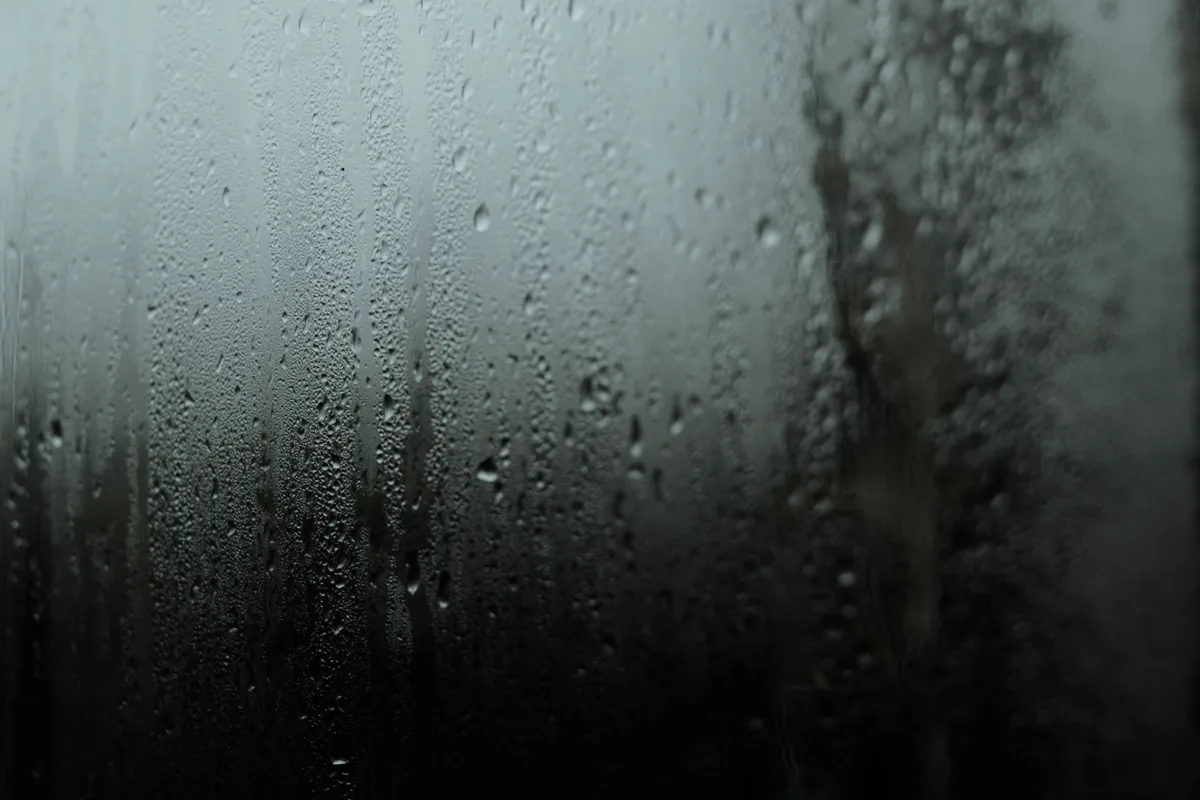 Cristal de una ventana empañado, con gotas de condensación y vaho