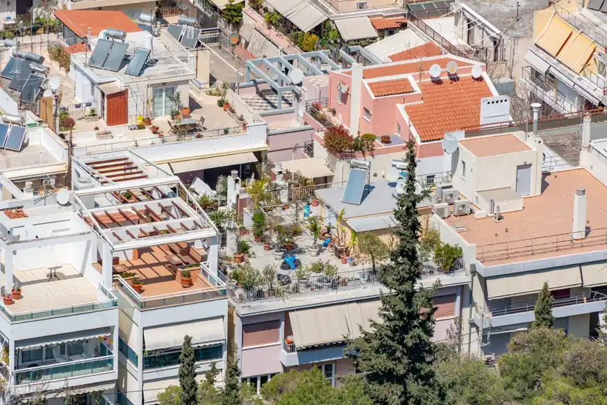 Azoteas planas y terrazas de edificios de viviendas con paneles solares y aparatos de aire acondicionado