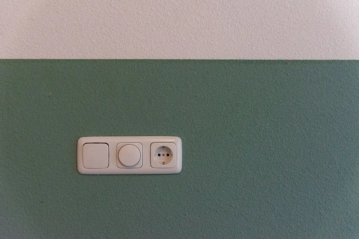 Interruptor, regulador de luz y enchufe en la pared de una vivienda