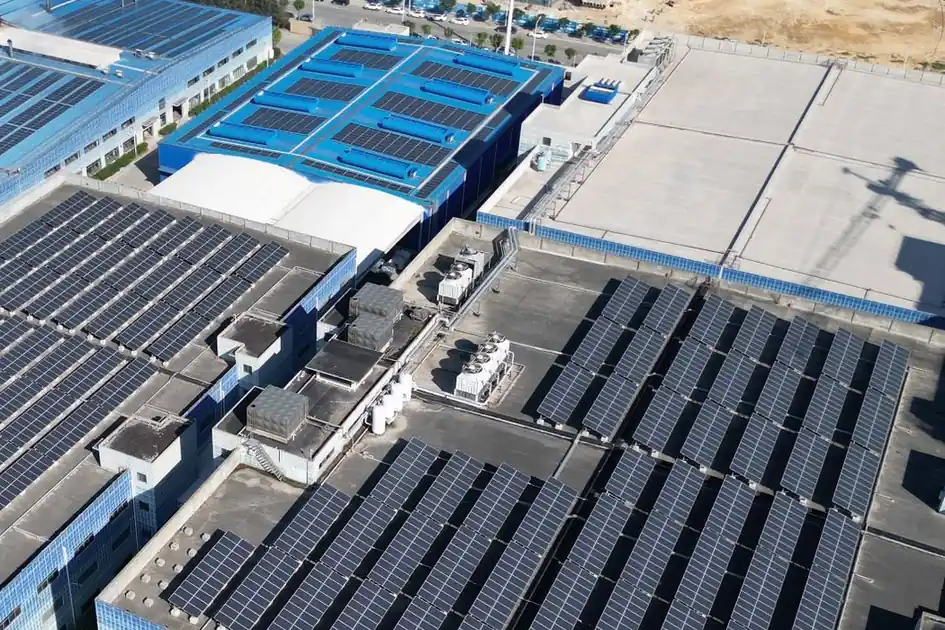 Placas solares sobre las cubiertas planas de varios edificios industriales, vistas desde arriba